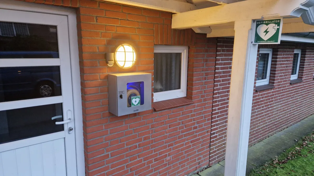 Defibrillator (AED) in einem Wandkasten an der Außenwand des Gerätehauses
